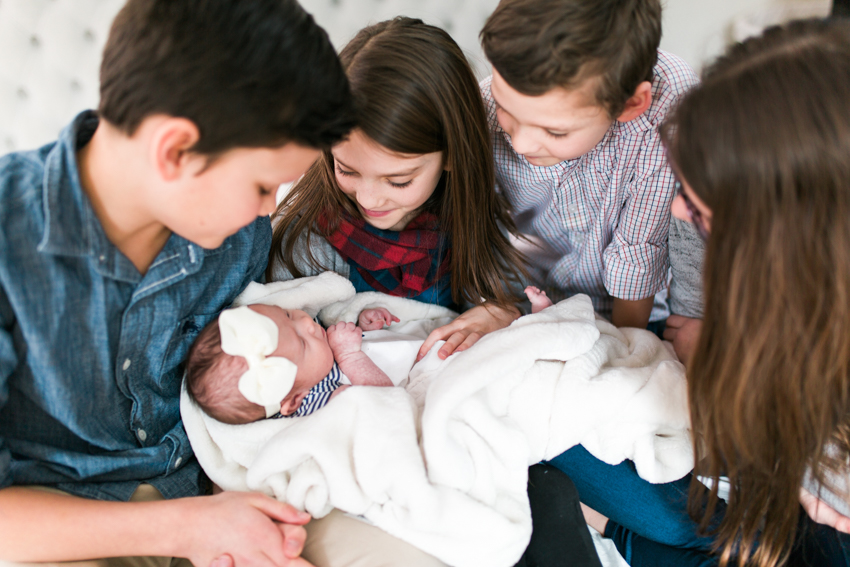 children surrouning baby